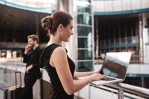 Mujer usando su laptop en el aeropuerto — Foto de Stock