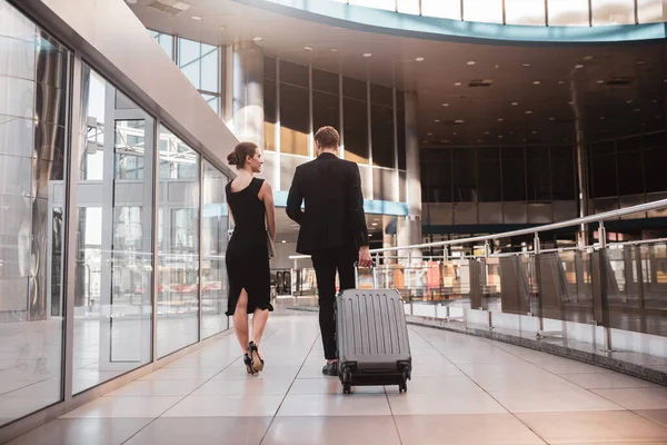Frau und Mann tragen ihren Koffer durch den Flughafen — Stockfoto