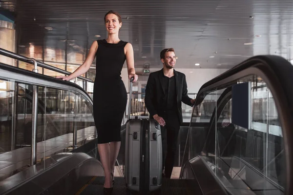 Frau und Mann benutzen Rolltreppe im Flughafen — Stockfoto