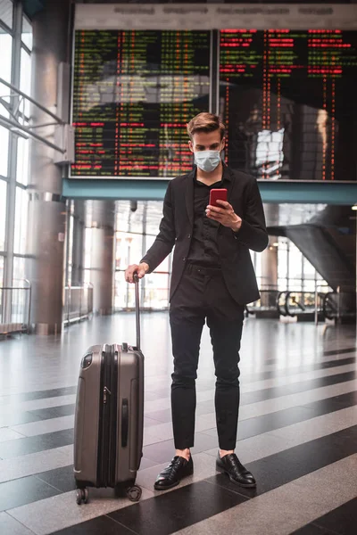 Чоловік використовує свій смартфон в аеропорту — стокове фото