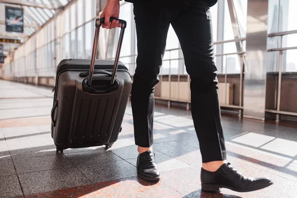 Чоловік несе валізу через аеропорт — стокове фото