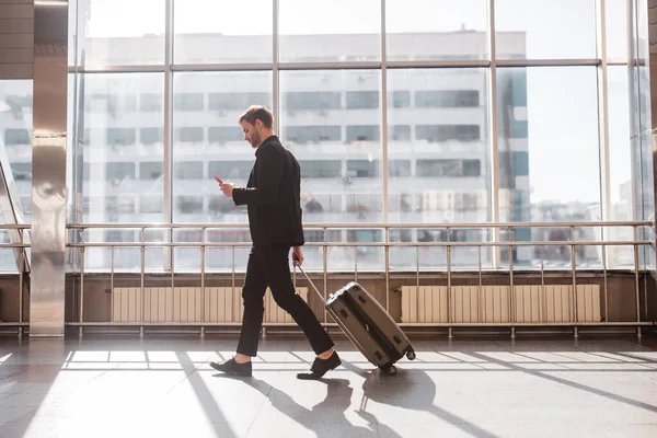 Man walking through the airport with the luggage — Stock Photo, Image