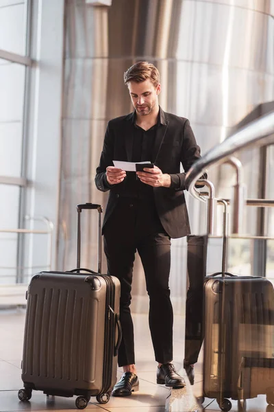 Man die reisdetails leest in zijn baording pass — Stockfoto