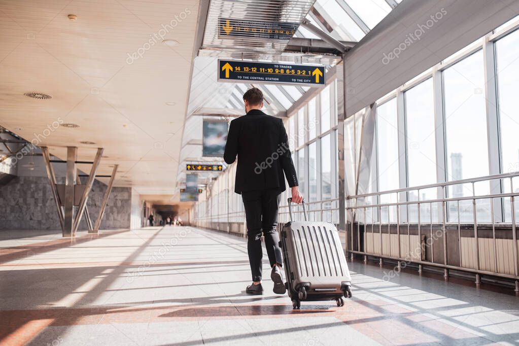 Man carrying his luggage through the airport