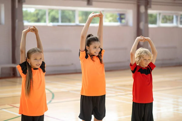 Three kids doing stretching in the gym — Stock Photo, Image