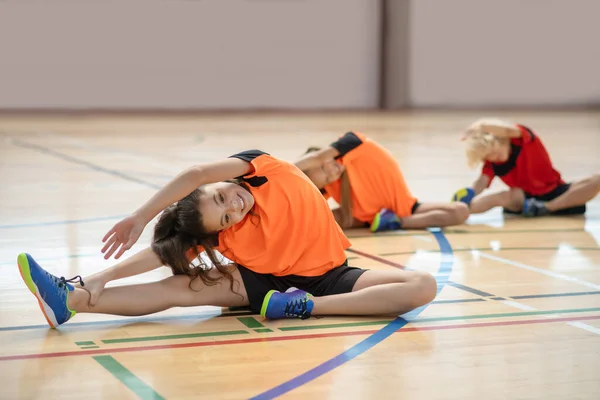 Niños en ropa deportiva brillante haciendo ejercicio en el gimnasio — Foto de Stock
