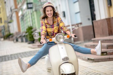 Scooter sürerken dengeyi sağlamaya çalışan bir kadın