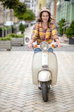 Heyecanlı kadın scooter sürmeyi öğreniyor.