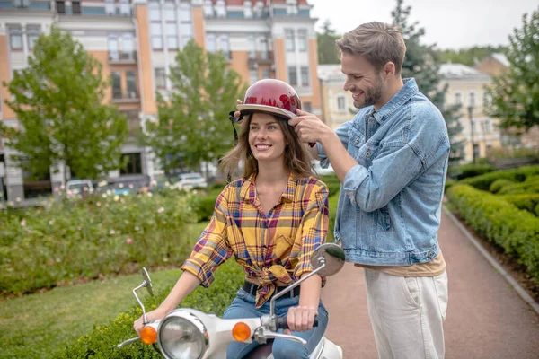 Hombre poniéndose un casco en la cabeza de las mujeres — Foto de Stock