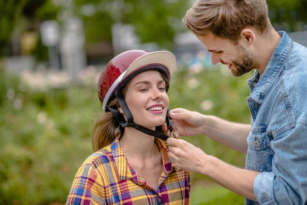 Hombre fijando un casco en la cabeza de las mujeres — Foto de Stock