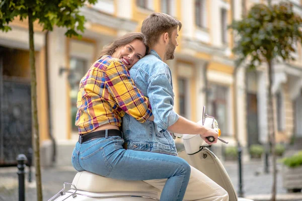 Mulher abraçando um homem enquanto monta uma scooter — Fotografia de Stock