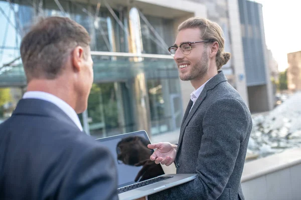 Twee mannelijke collegaues controleren laptop, bespreken zakelijke kwesties buiten — Stockfoto