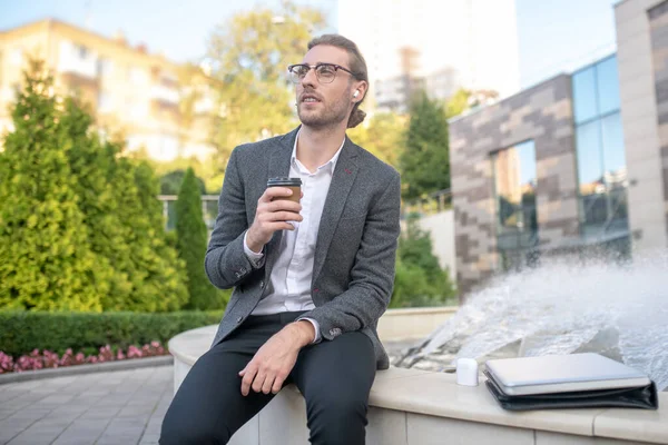 Manlig kontorsarbetare njuter av kaffe nära fontänen — Stockfoto