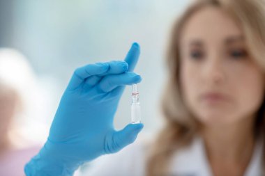 Genç hemşirenin bir ampul taşıdığı yakın plan.