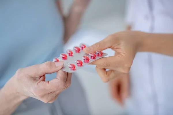 Close-up van de menselijke hand geven van de blaren met pillen — Stockfoto