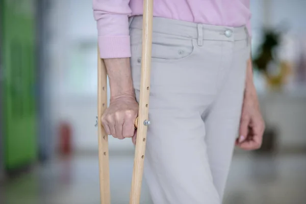 Крупный план пожилой женщины с костылем — стоковое фото