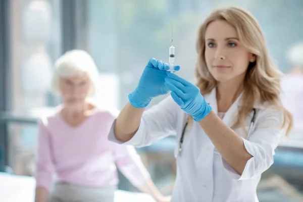 Leuke vrouwelijke verpleegster die een ampul met vaccin vasthoudt — Stockfoto
