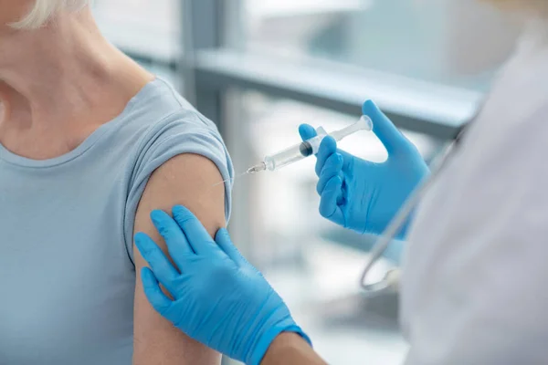 Закрыть фотографию медсестер, держащих шприц перед прививкой — стоковое фото