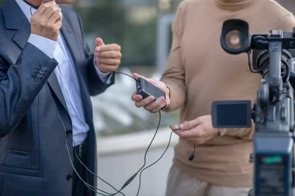 Primer plano de dos pares de manos masculinas sosteniendo los auriculares delante de la cámara —  Fotos de Stock