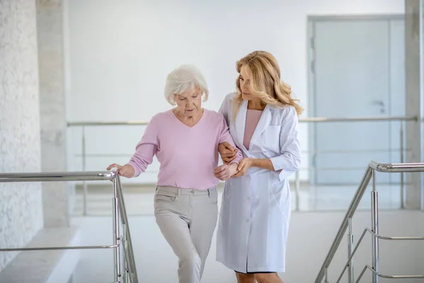 Äldre kvinna och hennes läkare går upp — Stockfoto