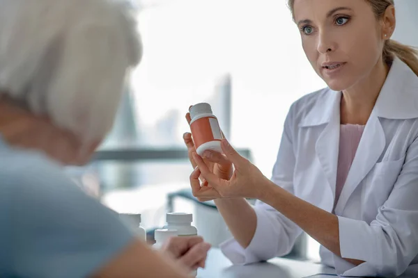 Doctora consultando a una paciente anciana sobre medicamentos — Foto de Stock
