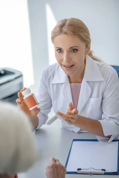 Doctor consulting an elderly patient regarding medication and looking excited
