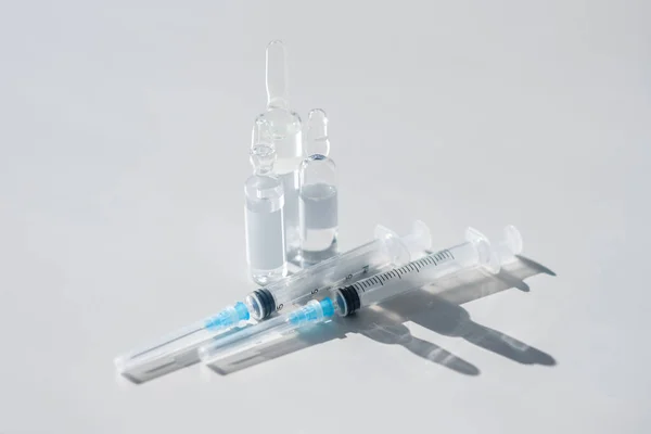 Пробирки с вакциной и шприцами на столе — стоковое фото