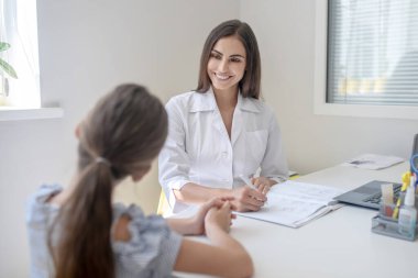 Klinikte bir kadın doktorla özel ders alan bir kız.