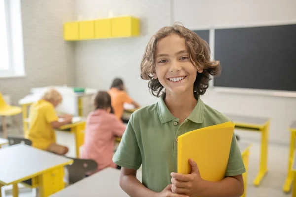 Lindo colegial en camiseta verde sonriendo muy bien —  Fotos de Stock