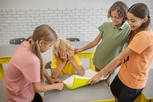 Ein Junge im gelben T-Shirt leidet unter Mobbing seiner Klassenkameraden — Stockfoto