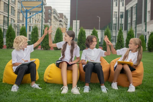 Children sitting on bag chairs and feeling cheerful — Stock Photo, Image