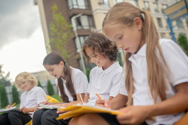 Crianças fazendo anotações e olhando concentrado — Fotografia de Stock