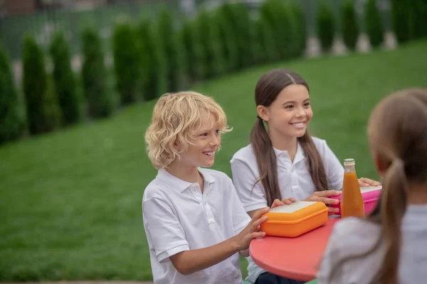 Děti spolu obědvají a vypadají radostně — Stock fotografie