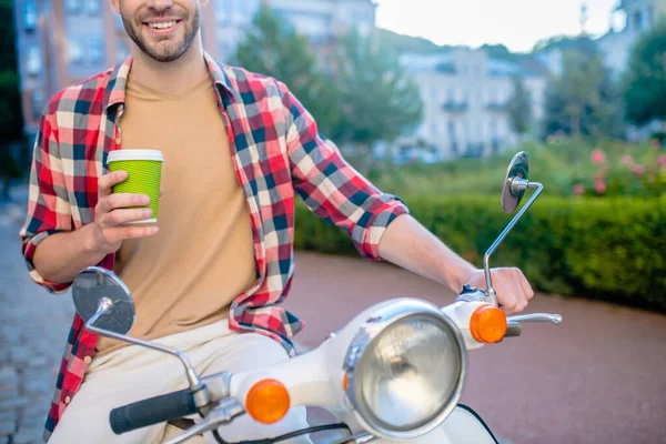 Mann fährt Roller und trinkt Kaffee — Stockfoto