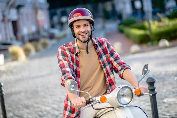 Mann mit rotem Helm auf Motorroller unterwegs — Stockfoto