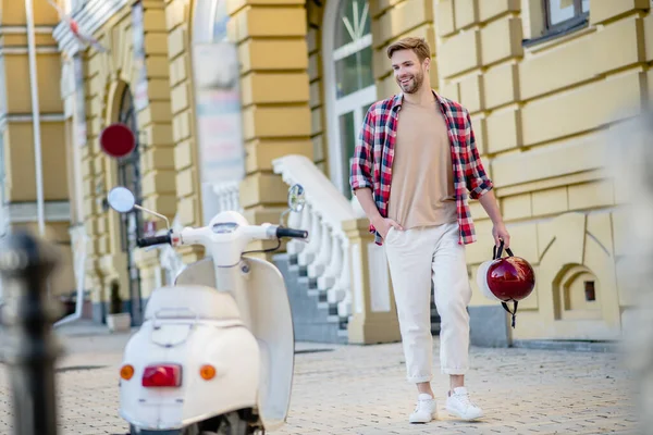 Улыбающийся человек готовится к поездке на своем белом мотоцикле — стоковое фото