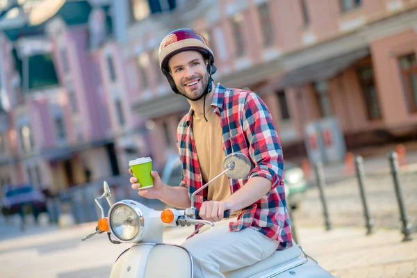 Hombre sonriente tomando un café por la mañana mientras cabalga al trabajo — Foto de Stock