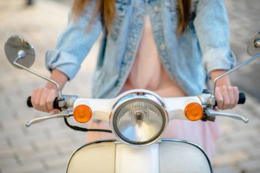 Beyaz scooter kullanan şık bir kadın.