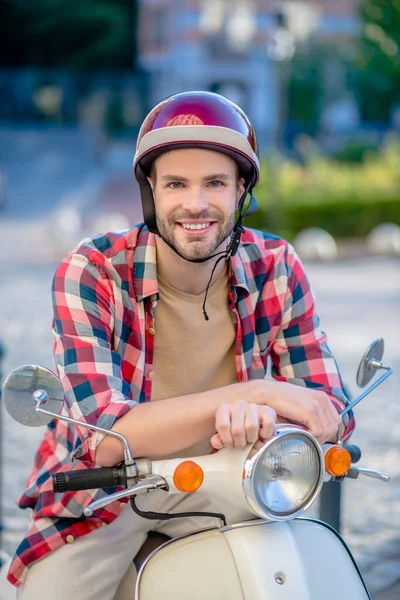 Junger schöner Mann in Hanf sitzt auf einem Motorroller — Stockfoto