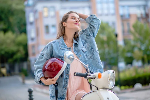 Wanita ceria memegang helm moto merah — Stok Foto