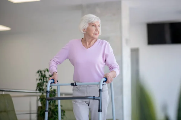 Una anciana con un andador que mira a un lado — Foto de Stock