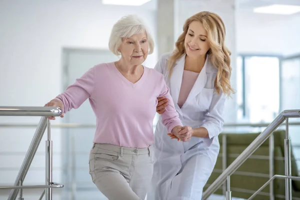 Dokter in een labjas helpt haar patiënt — Stockfoto