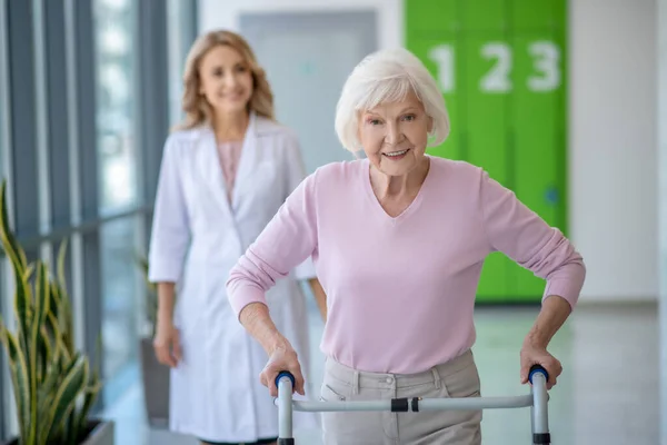 Oudere vrouw met rollator met rehabilitatie procedures in de kliniek — Stockfoto