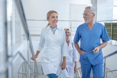 Profesyonel doktorlardan oluşan bir grup yukarı çıkıp bir şeyi tartışıyor.