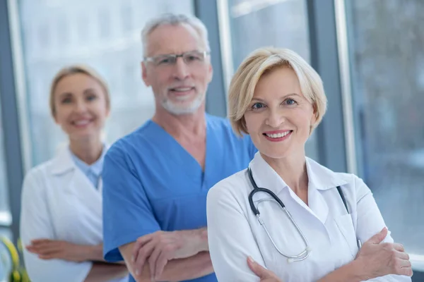 Grupo de trabajadores médicos sonrientes posando con los brazos cruzados — Foto de Stock