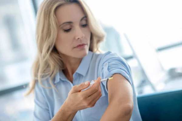 Mujer rubia haciendo inyección en su brazo — Foto de Stock