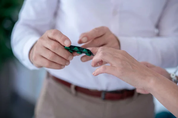 Close-up of male and female hands holding pill blister pack — Stock Photo, Image