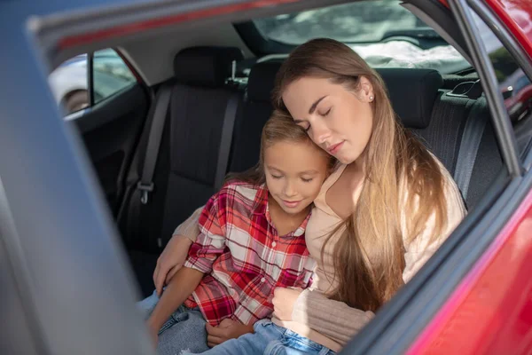 Memnun bir kız ve annesi arabanın arka koltuğunda uyukluyorlar. — Stok fotoğraf