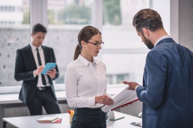 Kadın ve erkek tartışıyor, meslektaşı pencerenin kenarında.