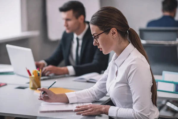 Geschäftsfrau mit Brille im Profil und zwei Männern — Stockfoto